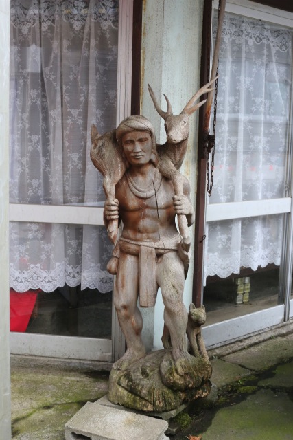 鹿を担ぐ人。木彫の置物。東尋坊の土産物街にある。